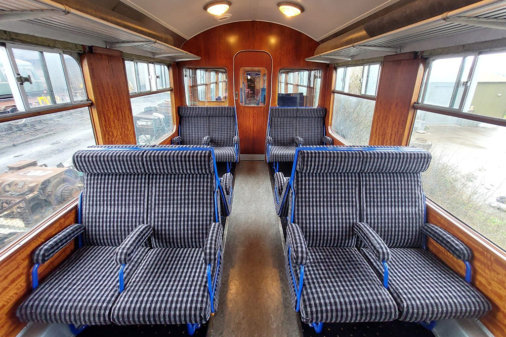 Restored interior of 1950s railcar, first class seats with arm rests in blue moquette